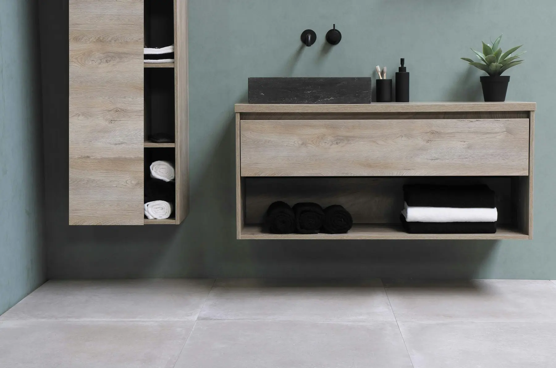 A timber vanity unit with a mirror above and folded towels on the shelf below