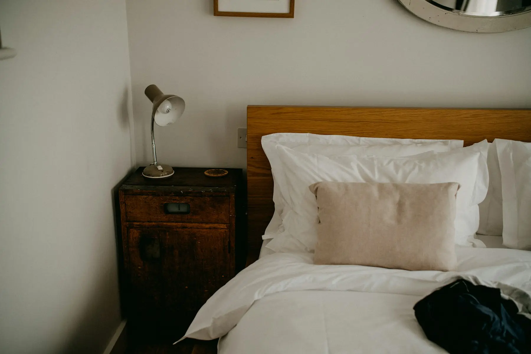 The bedroom at Lachica Homes with a timber-framed queen bed, white bedding and a wooden bedside table