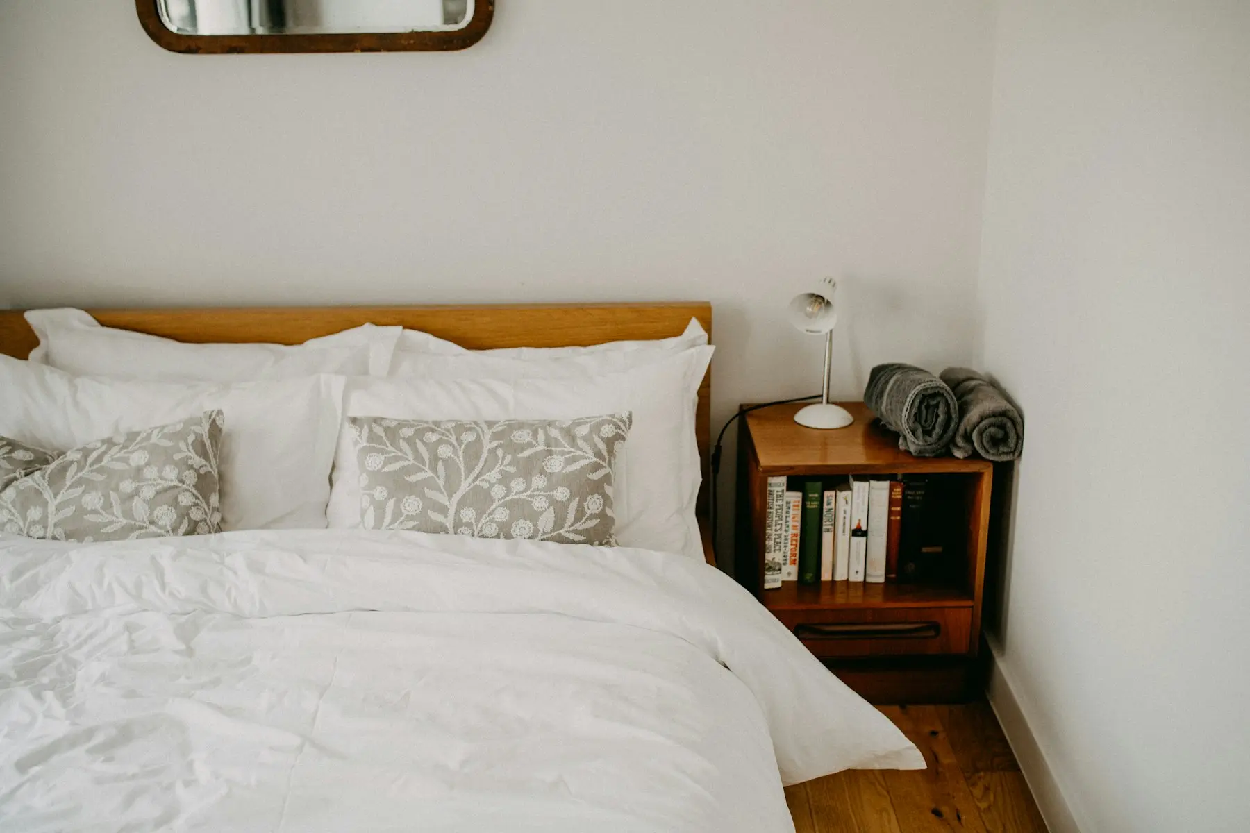 The bedroom seen from the doorway, with the bed made and a lamp on the bedside table
