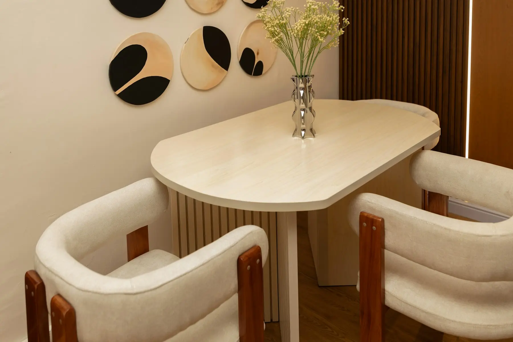 A small round dining table set for two with fresh flowers