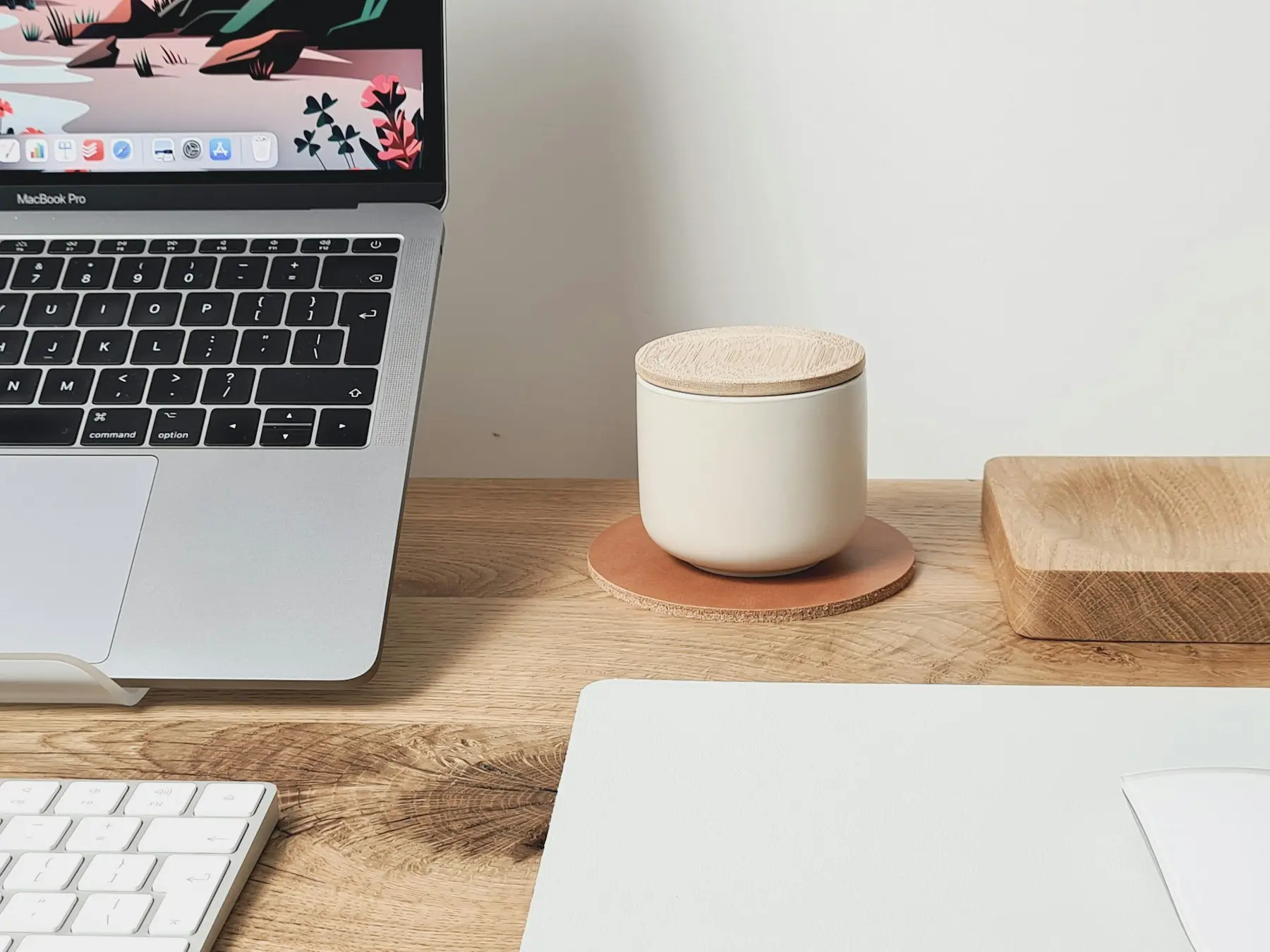 A laptop and a mug of coffee on the timber desk by the window